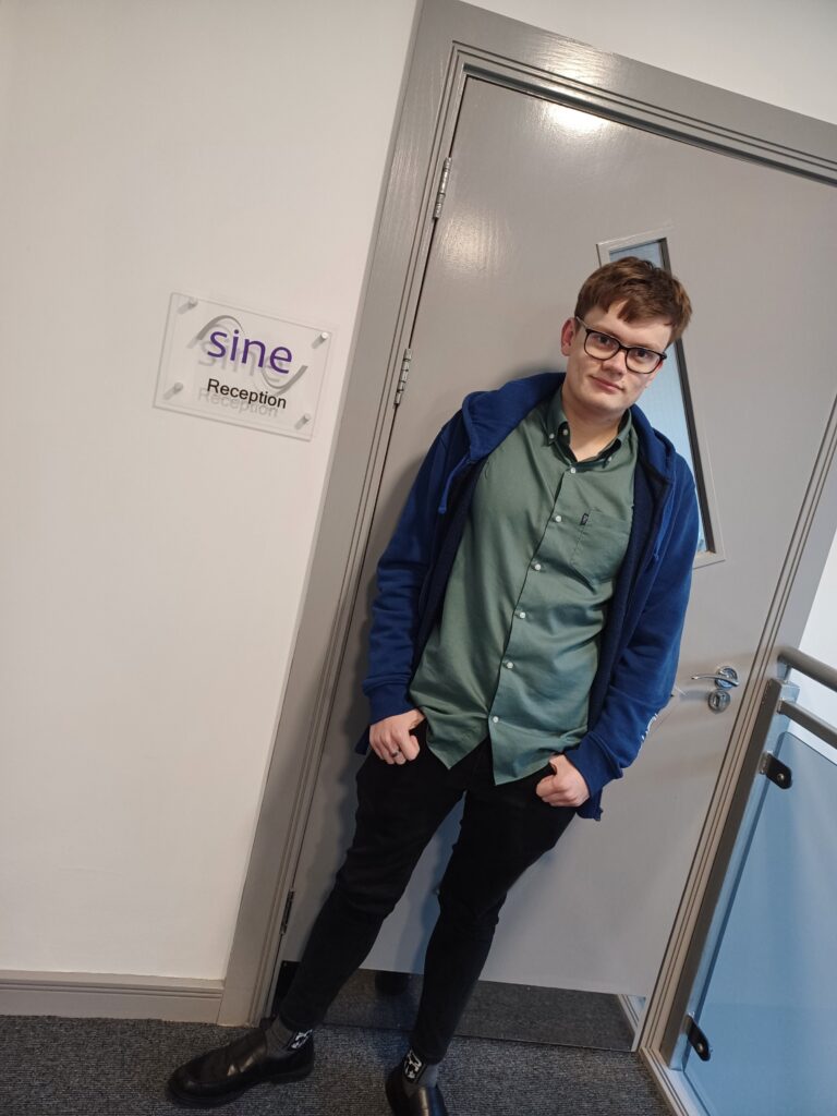 An employee stood in front of a door at Sine Consulting Ltd.