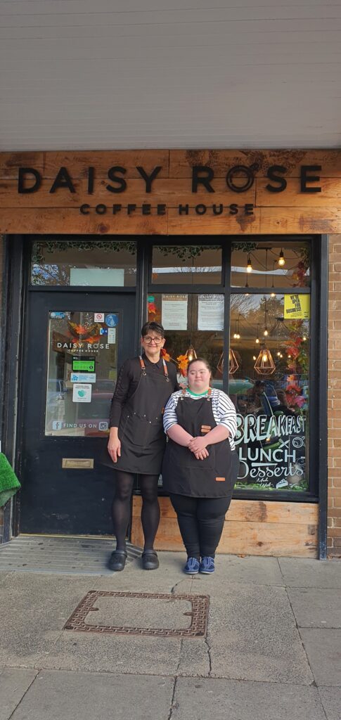 Lucy and her employer standing proudly outside the Daisy Rose Coffee House in Durham.