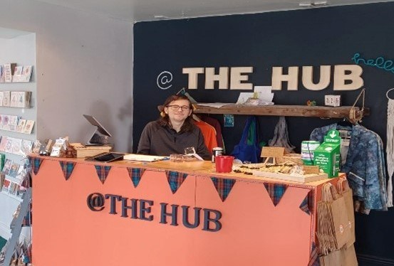 Ethan standing proudly behind the front desk of The HUB in Consett.