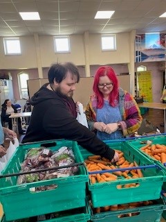 Oliver and a co-worker from The Bread and Butter Thing packing vegetables.