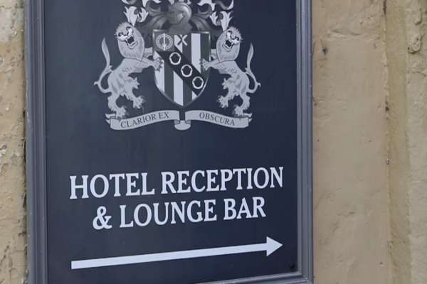 a hotel reception and lounge bar sign on the side of a building