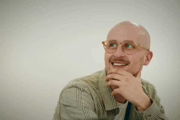 James looking to someone out of view, smiling